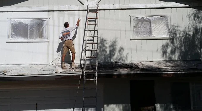 Painter applying a bright exterior coating to a home
